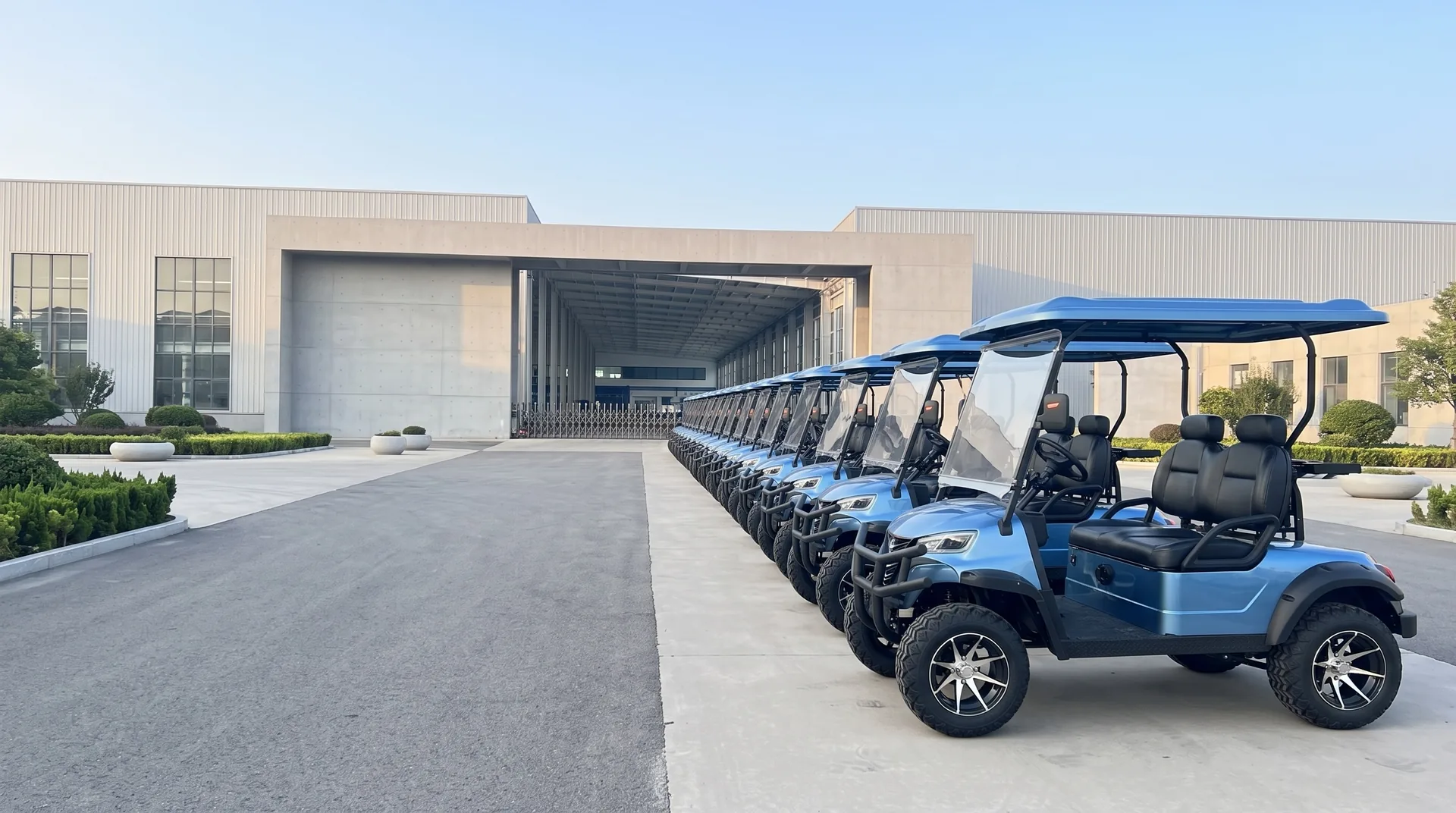 Blue electric golf carts lined up outside the Waygo factory