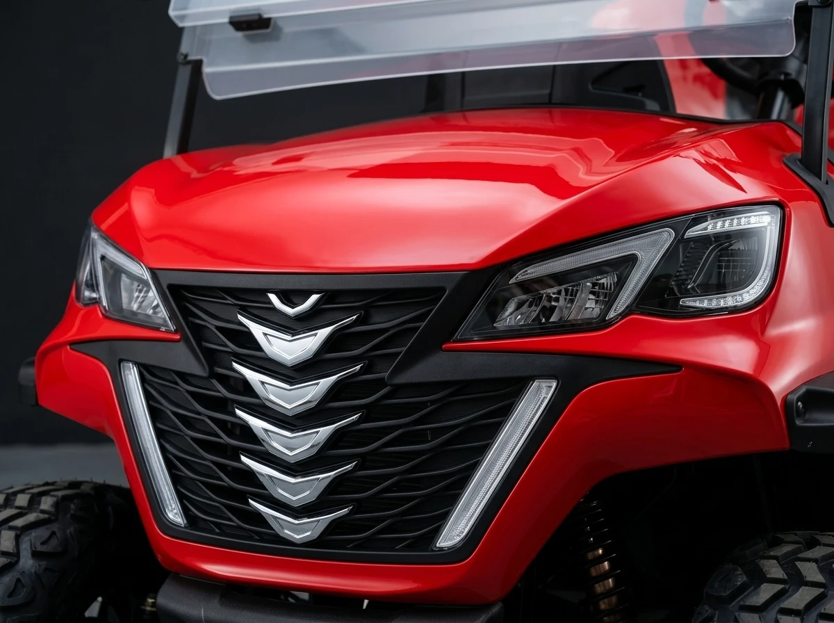 Front-end and headlight detail of a red electric golf cart