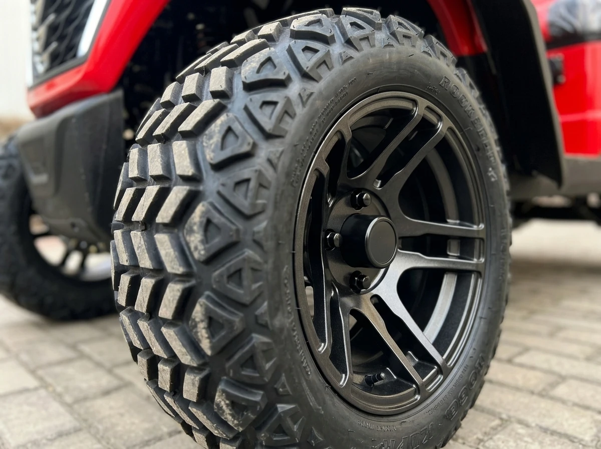 Tire and wheel detail of a red electric golf cart